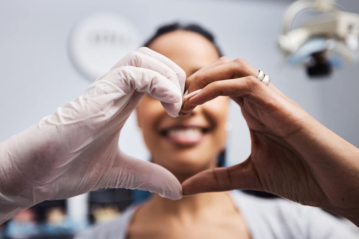 patient and dentist making heart hands